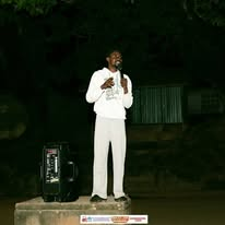 A preacher sharing the Gospel during an evening outreach